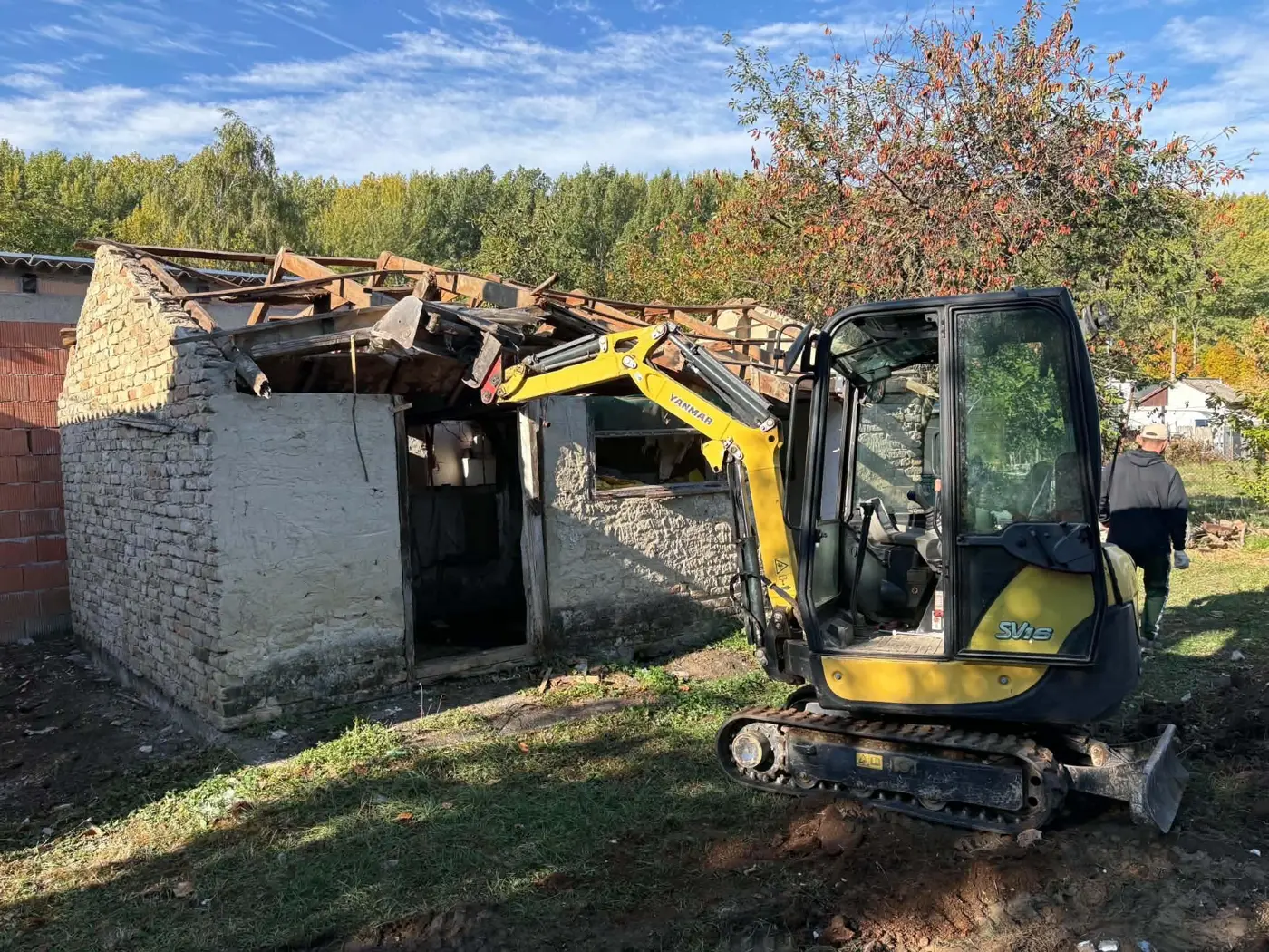 A minikotró a tetőszerkezetet bontja